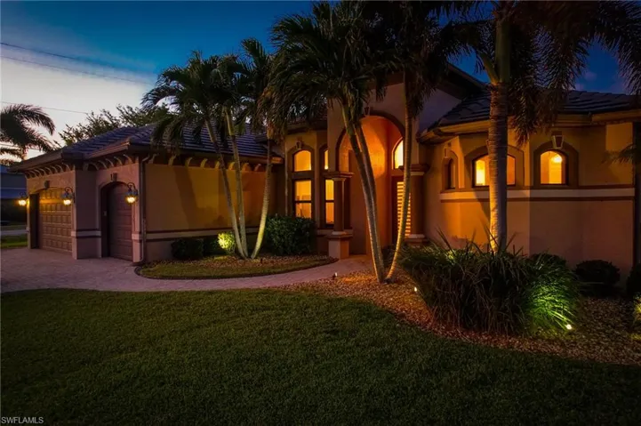 Mediterranean / spanish-style home with a garage and a yard