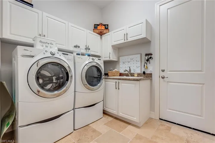 Laundry area featuring cabinets, sink, and washer and dryer