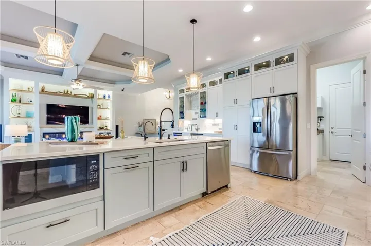 Kitchen featuring sink, a kitchen island with sink, pendant lighting, appliances with stainless steel finishes, and white cabinetry