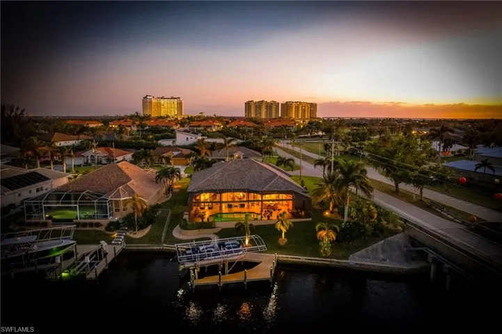 Aerial view at dusk featuring a water view