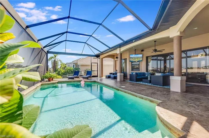 View of pool featuring a patio area, ceiling fan, a lanai, and an outdoor hangout area