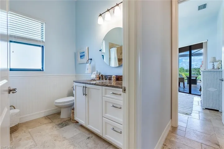 Bathroom with vanity, a healthy amount of sunlight, toilet, and a shower with curtain