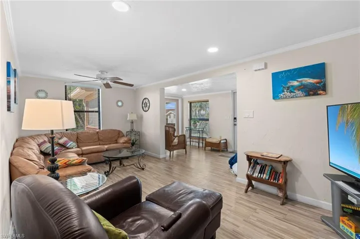 Living room featuring comfortable seating and an open layout that flows seamlessly into the dining area  - Virtually Edited Image