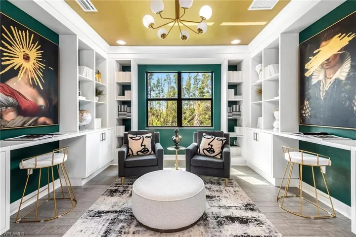Sitting room with a chandelier, built in shelves, and hardwood / wood-style floors