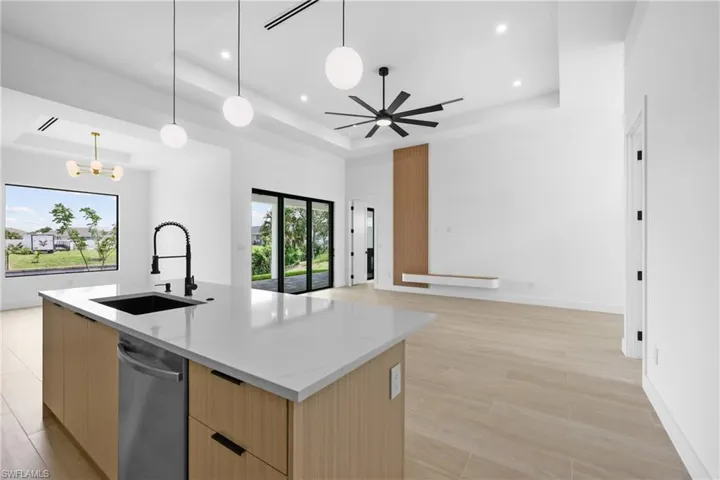 Kitchen featuring modern cabinets, light brown cabinets, light stone countertops, and recessed lighting