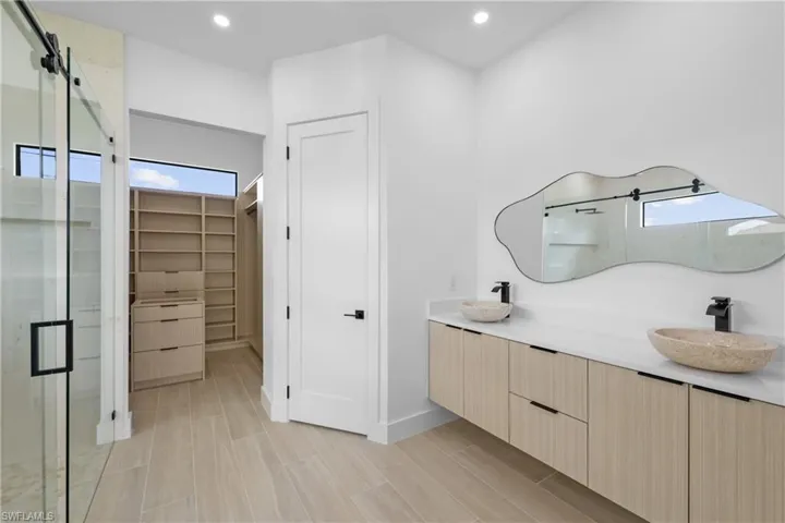 Kitchen featuring a tray ceiling, open floor plan, modern cabinets, light brown cabinetry, and recessed lighting