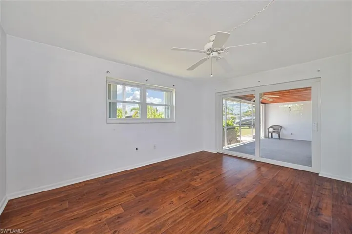 Empty room with baseboards, a ceiling fan, and hardwood / wood-style flooring