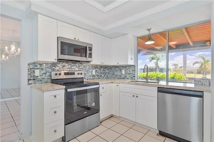 Kitchen with a sink, stainless steel appliances, tasteful backsplash, and light tile patterned floors