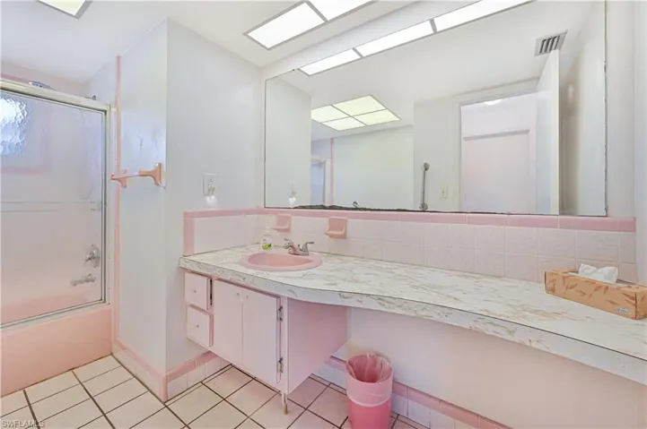 Full bath featuring vanity, visible vents, tile patterned flooring, combined bath / shower with glass door, and tasteful backsplash