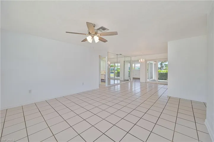 Unfurnished room with light tile patterned flooring, visible vents, and ceiling fan