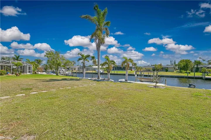 Dock area with a yard and a water view