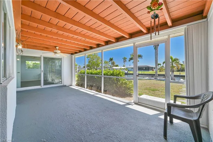 Unfurnished sunroom with beam ceiling and a ceiling fan