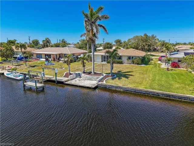 View of dock featuring a lawn, a water view, and a residential view