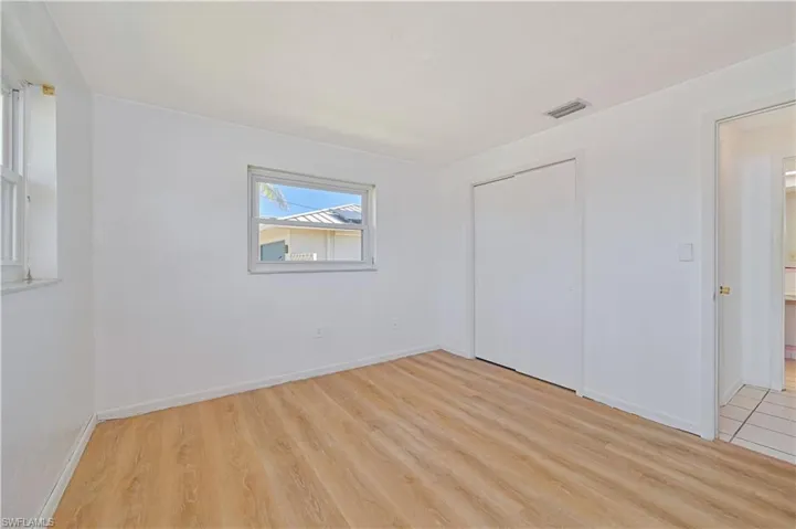 Unfurnished bedroom featuring visible vents, baseboards, a closet, and light wood finished floors
