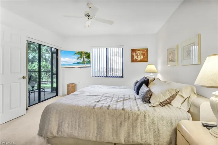 Bedroom with light colored carpet, access to exterior, and ceiling fan