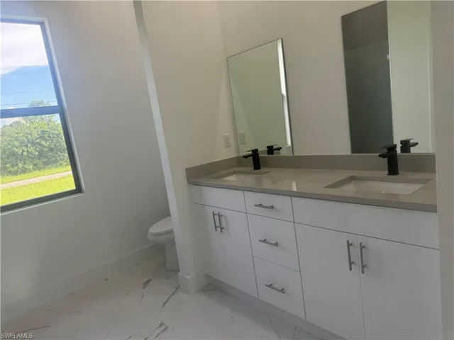 Bathroom featuring tile patterned floors, toilet, and vanity