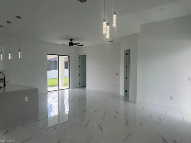 Empty room featuring ceiling fan and tile patterned flooring