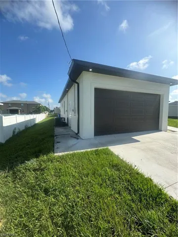 View of property exterior featuring a garage and a yard