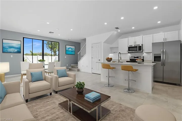 Living area with recessed lighting, stairway, and light tile patterned floors