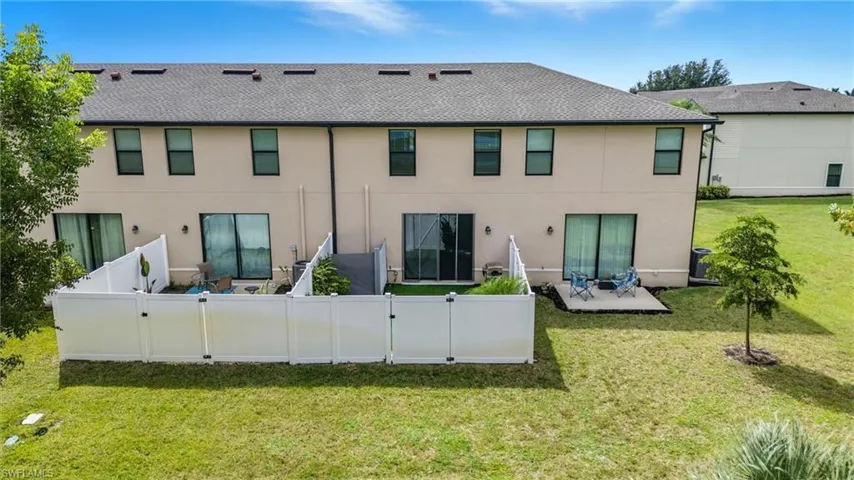Rear view of property featuring a patio area, stucco siding, and a shingled roof