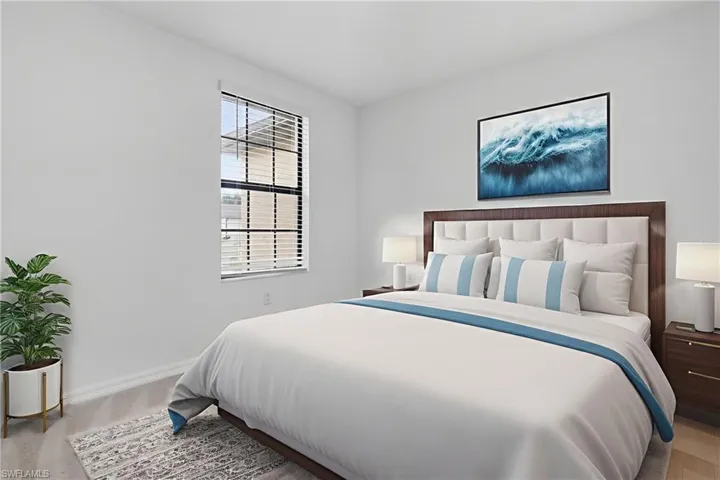 Bedroom featuring baseboards and light carpet