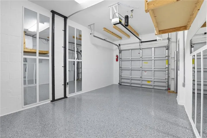 Garage featuring concrete block wall and a garage door opener