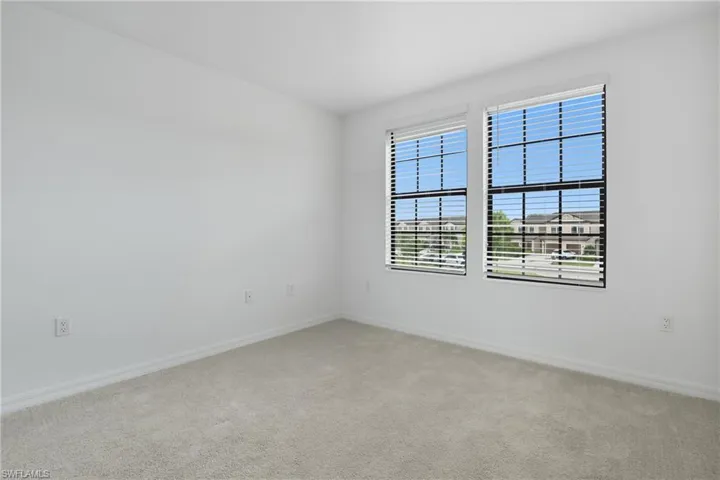 Empty room with light carpet and baseboards