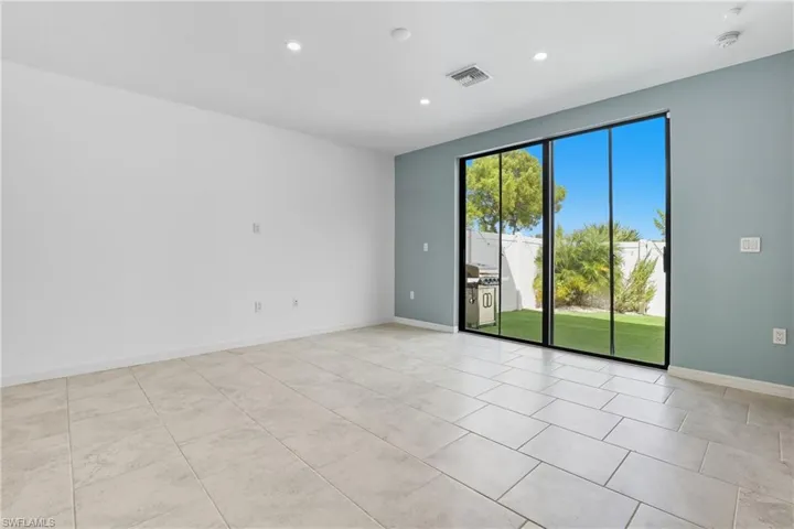 Empty room with recessed lighting and light tile patterned floors