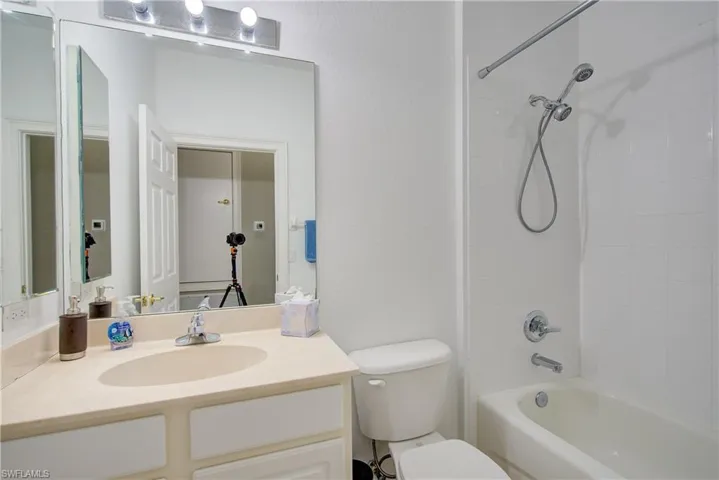 Full bathroom with vanity, toilet, and tiled shower / bath combo