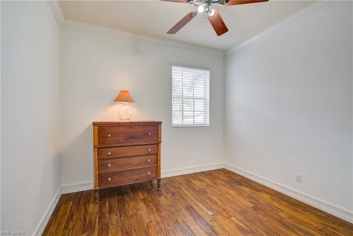 Unfurnished bedroom with crown molding, ceiling fan, and wood-type flooring