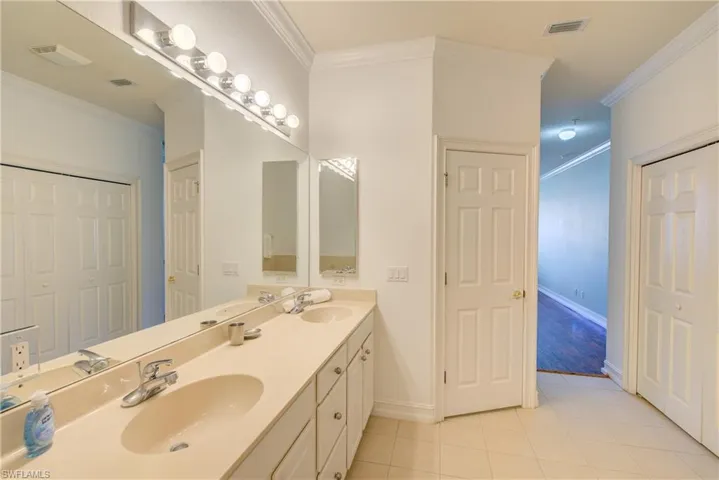 Bathroom with vanity, crown molding, and tile patterned floors