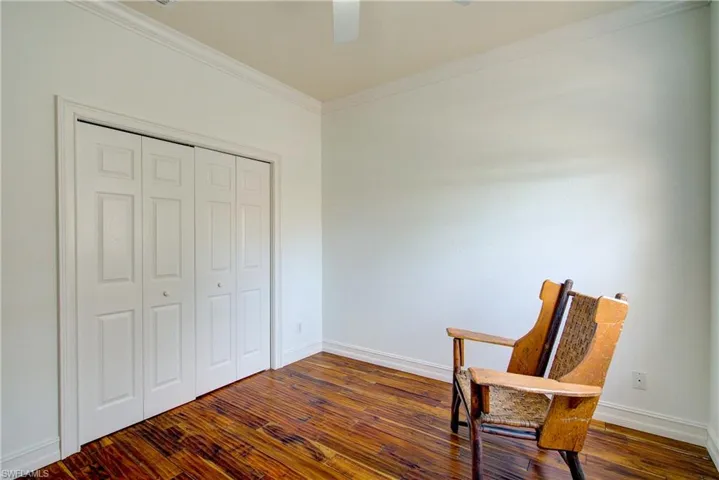 Living area featuring dark wood-type flooring and ornamental molding