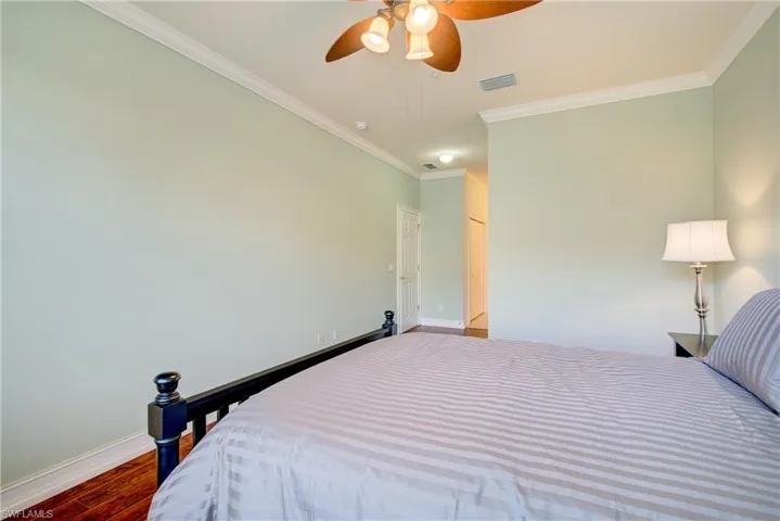 Bedroom featuring ceiling fan, ornamental molding, hardwood / wood-style floors, and a closet