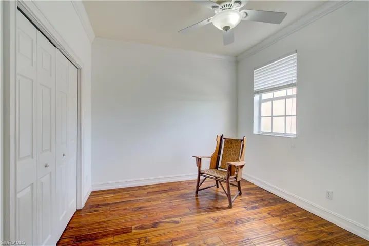 Living area featuring crown molding, ceiling fan, and wood-type flooring