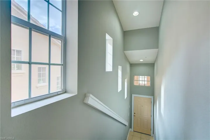Stairway featuring tile patterned floors, a high ceiling, and a wealth of natural light