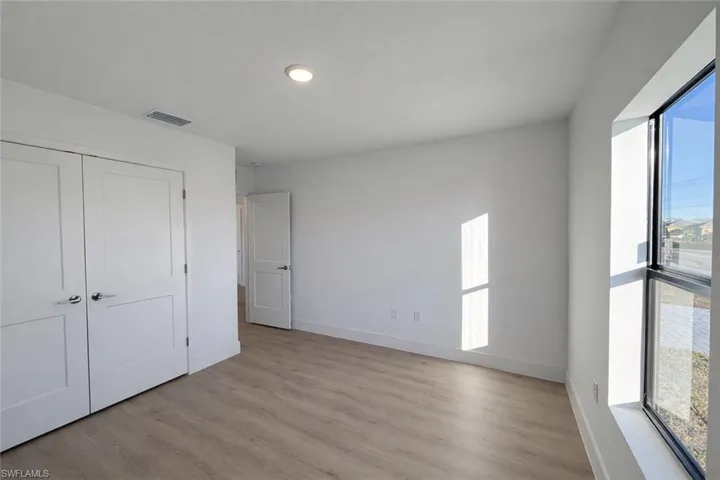 Unfurnished bedroom featuring light wood finished floors and a closet