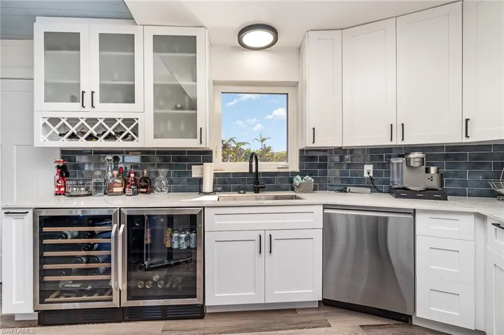 Contemporary kitchen featuring white cabinetry, a blue subway tile backsplash, and quartz countertops