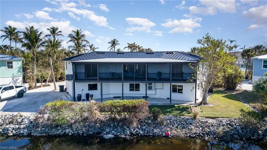 Two-story residence featuring a metal roof and screened upper-level balcony