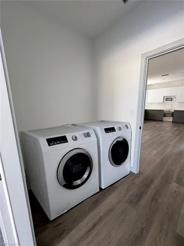 Laundry room featuring dark wood-style floors and separate washer and dryer