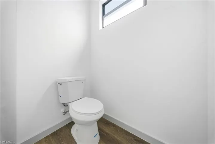 Bathroom featuring dark wood-type flooring and baseboards