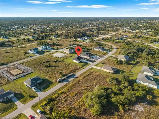Aerial view of property and surrounding area featuring nearby suburban area