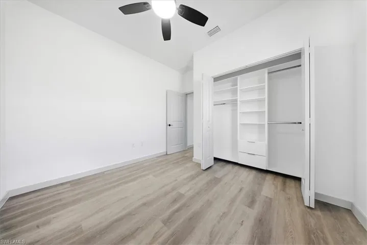Unfurnished bedroom featuring light wood finished floors, ceiling fan, and a closet