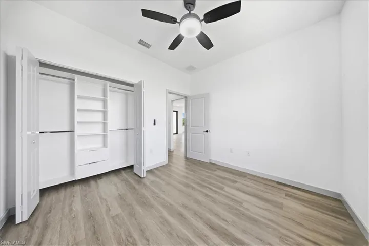 Unfurnished bedroom featuring light wood-style floors, a ceiling fan, and a closet