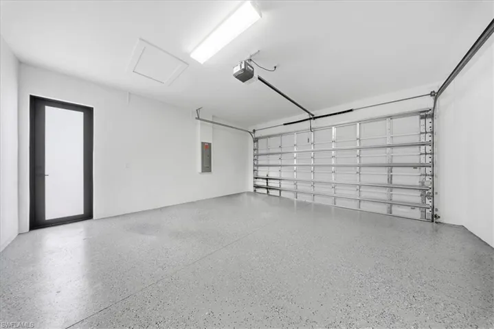 Garage with electric panel and a garage door opener