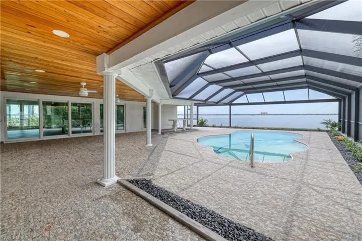 View of pool with a patio, ceiling fan, and a lanai