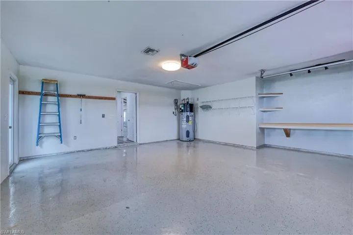 Garage featuring a garage door opener and heat pump water heater