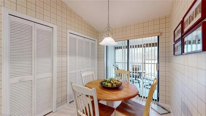 Tiled dining space featuring tile walls and vaulted ceiling