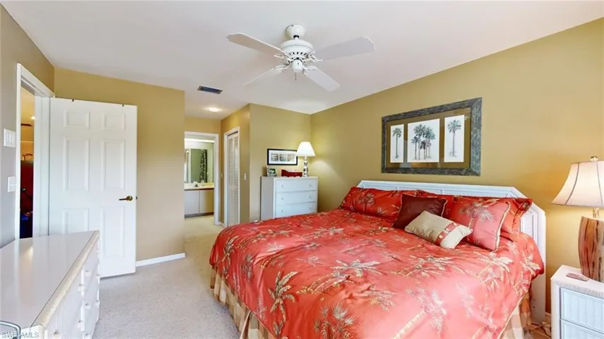 Bedroom with a closet, ceiling fan, and light colored carpet