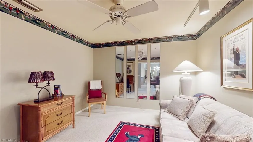 Carpeted living room featuring ceiling fan