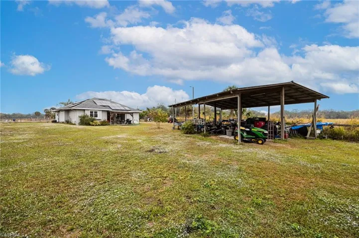 View of grassy yard with a carport